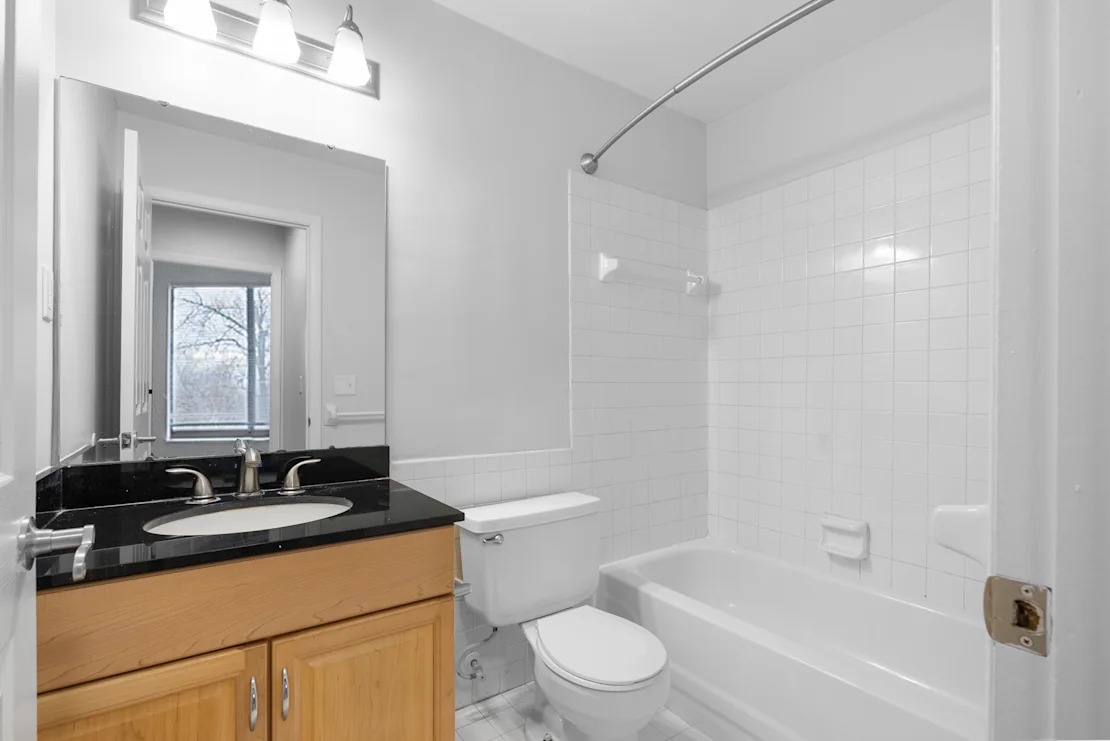 White bathroom with tub and espresso-colored cabinets