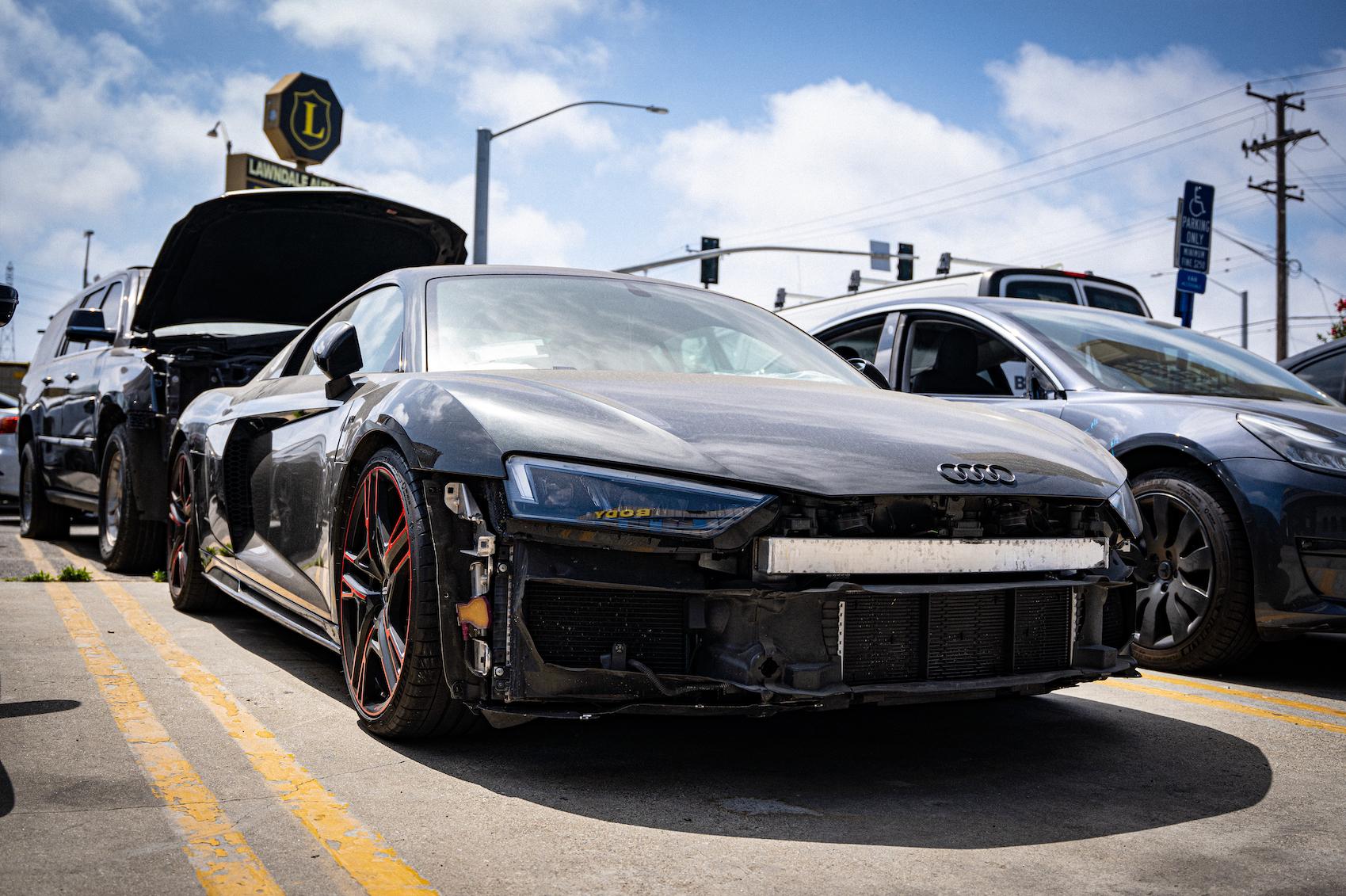 Detailed photo of Audi R8 waiting at auto body shop parking lot for collision repair