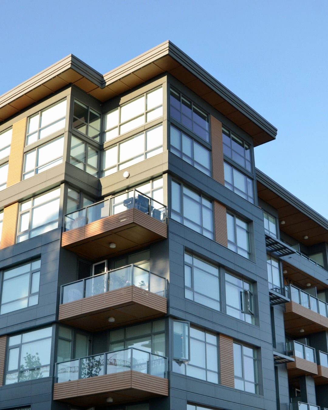 Modern multi-story apartment building featuring glass balconies, large windows, and contemporary architectural design. The residential property highlights upscale urban living, premium construction quality, and stylish exterior finishes suitable for luxury apartments or condominium developments in growing metropolitan communities.