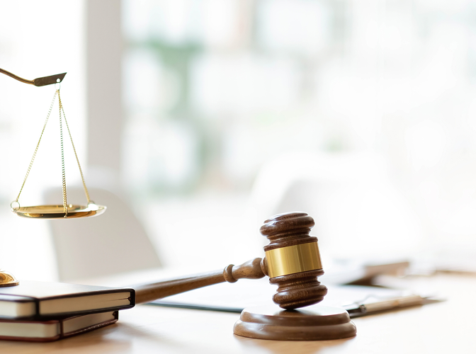 A gavel and the scales of justice on a desk.