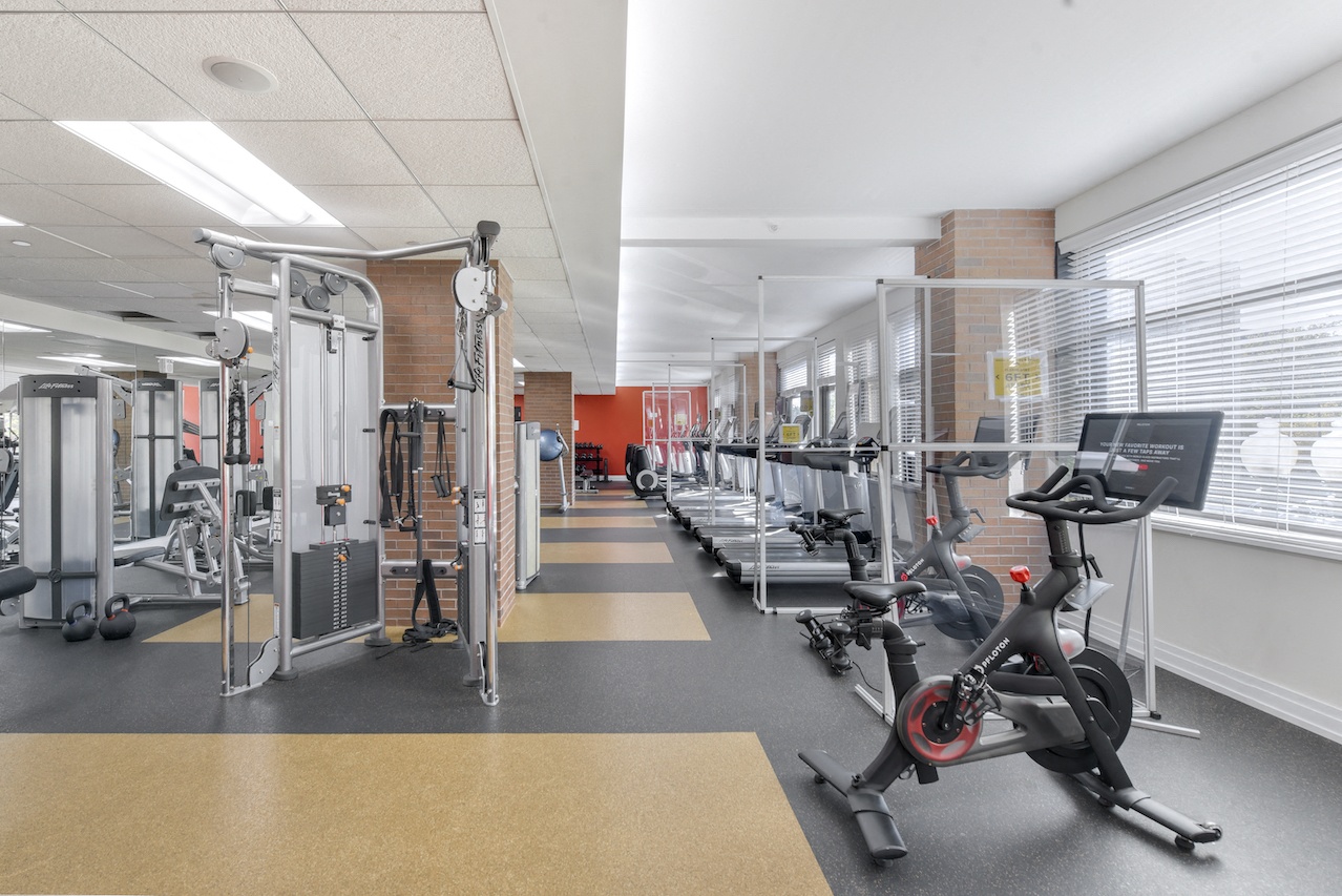 A gym with a variety of equipment including treadmills, weights, and exercise bikes.
