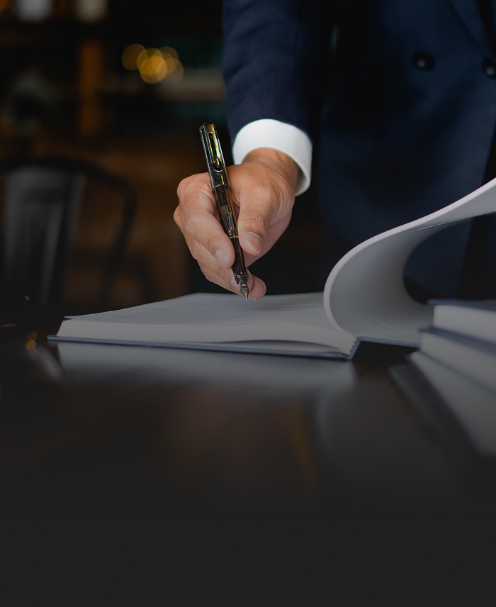 Close up of a man examining a document with a pen in hand.