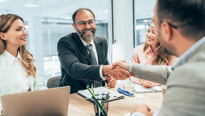 A client shaking hands with their advisor.