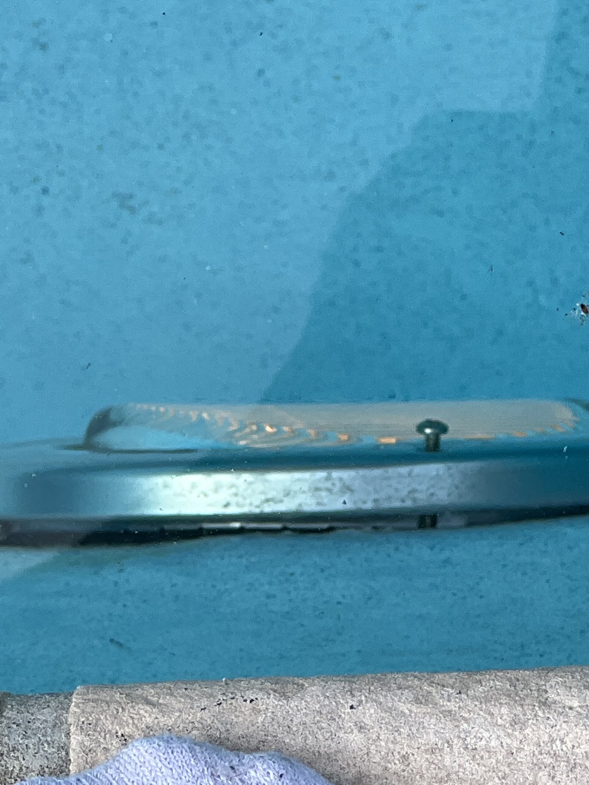 Close-up of a submerged pool light or fitting mounted on the swimming pool wall.