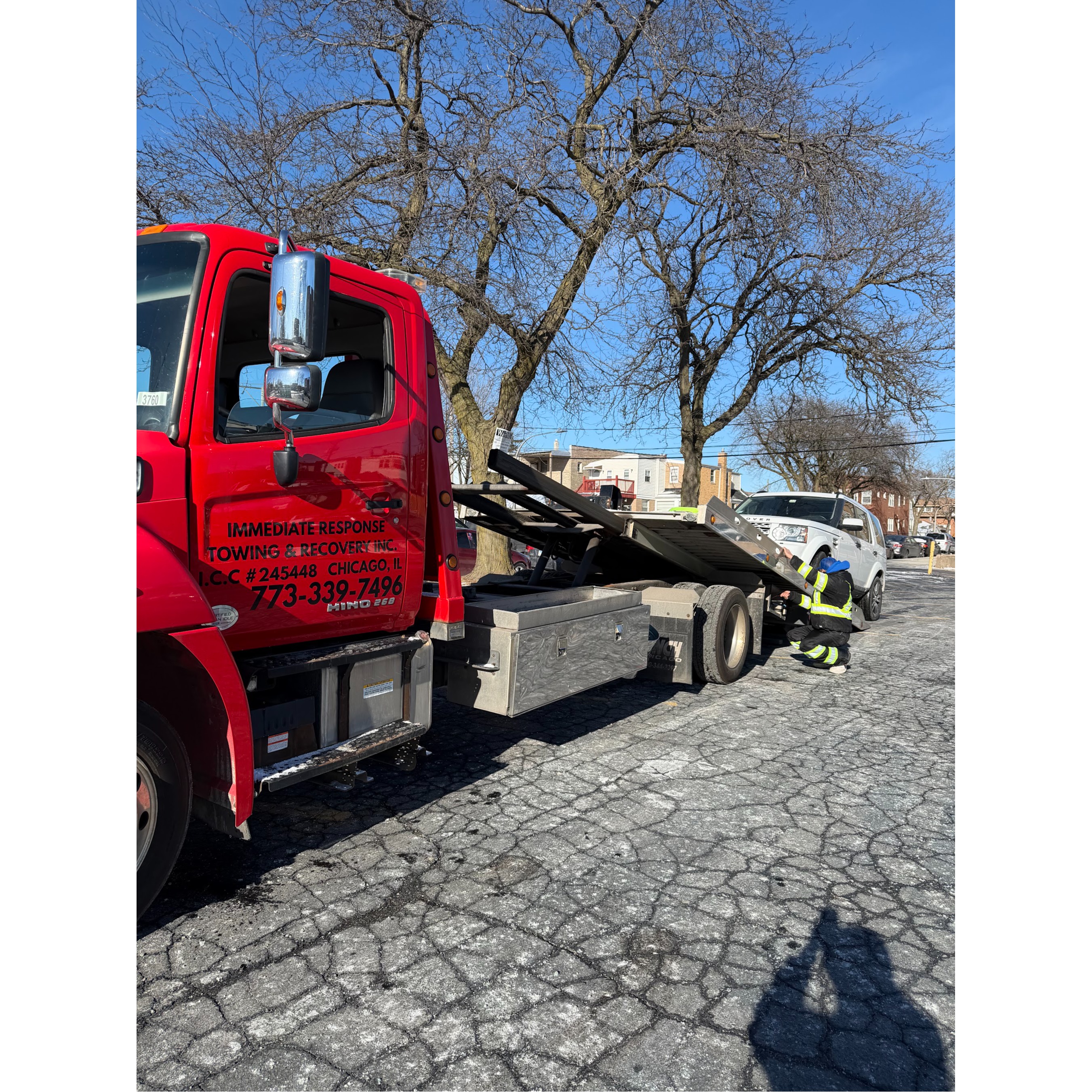 A red Immediate Response Towing & Recovery tow truck provides professional vehicle towing in Chicago 