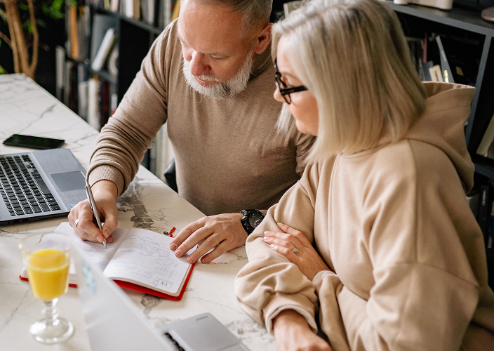 A couple writing in a notebook.