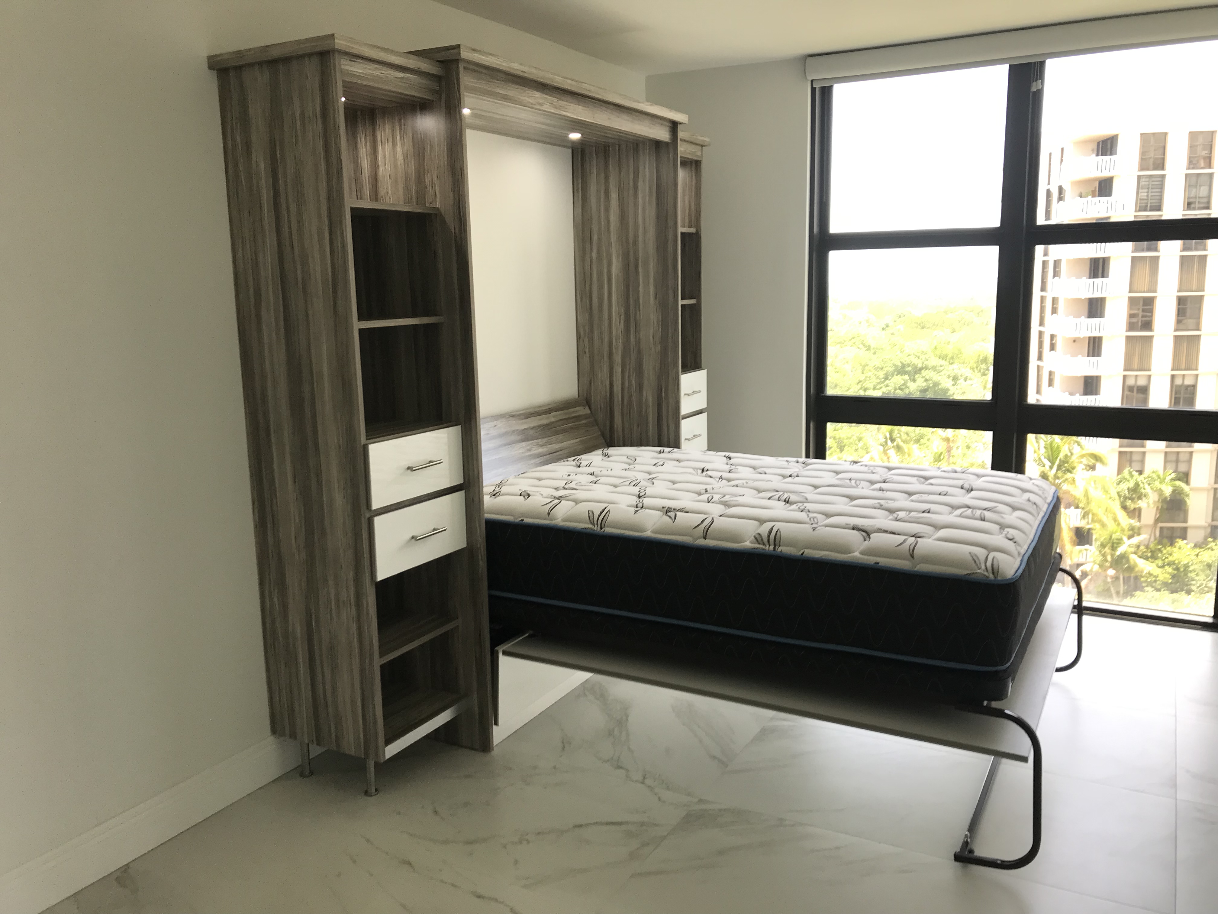 Modern Murphy bed open in wood wall unit with shelving and drawers