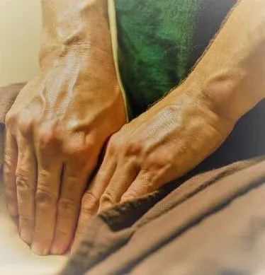 Close-up of therapist applying firm hand pressure during deep tissue massage, targeting muscles to r 