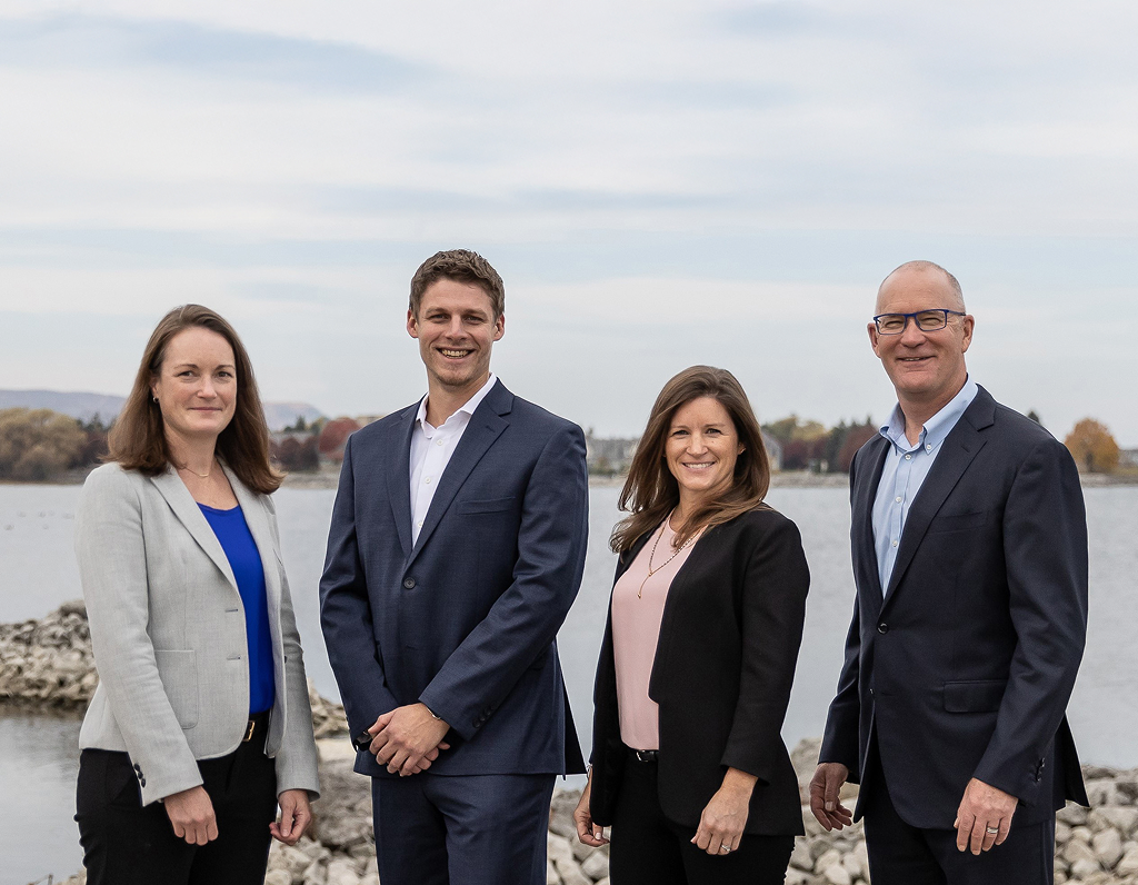 The Hodgson Koether Wealth Group posing in front of a lake.