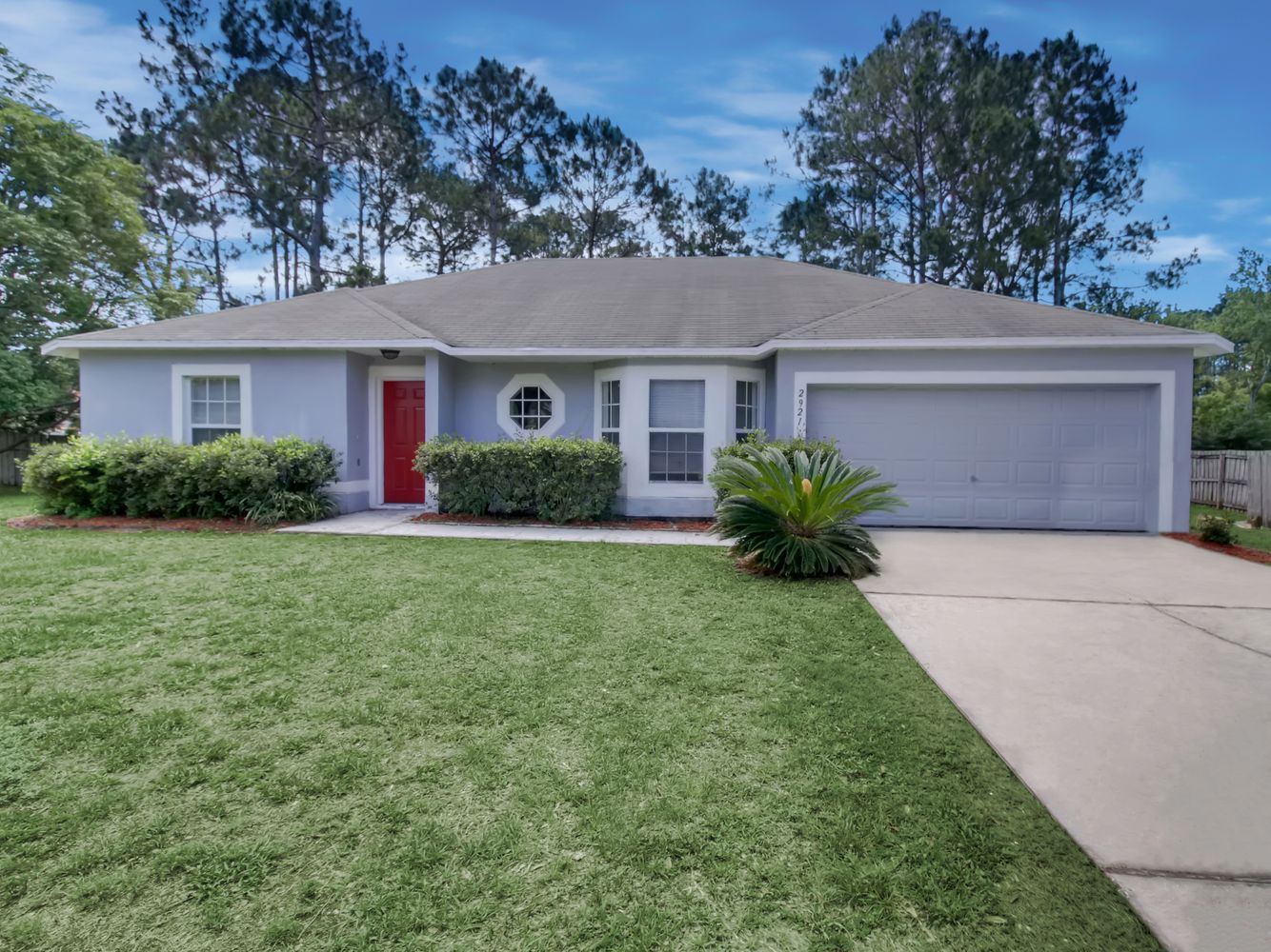 Beautiful home with a garage and landscaping at Invitation Homes Orlando.