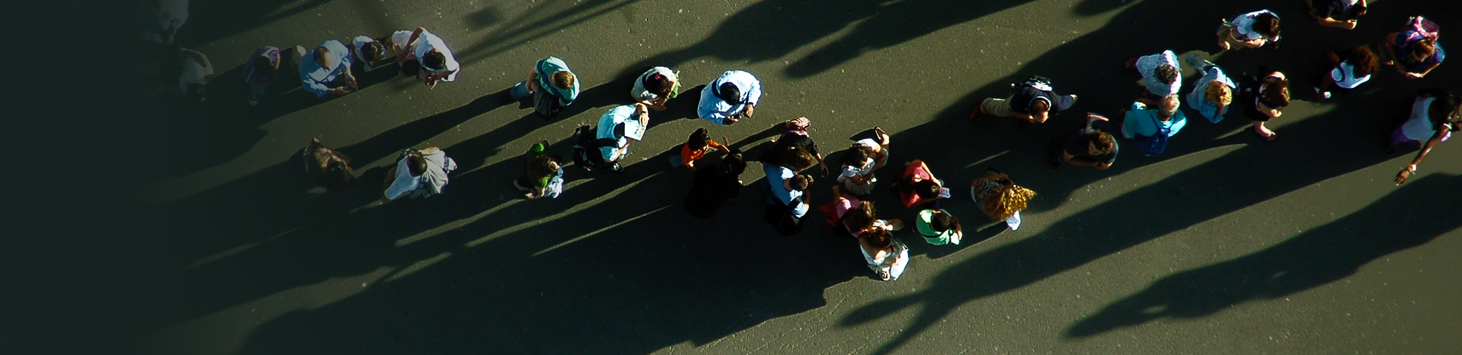 Top-down, aerial view of spectators chatting on a golf course.