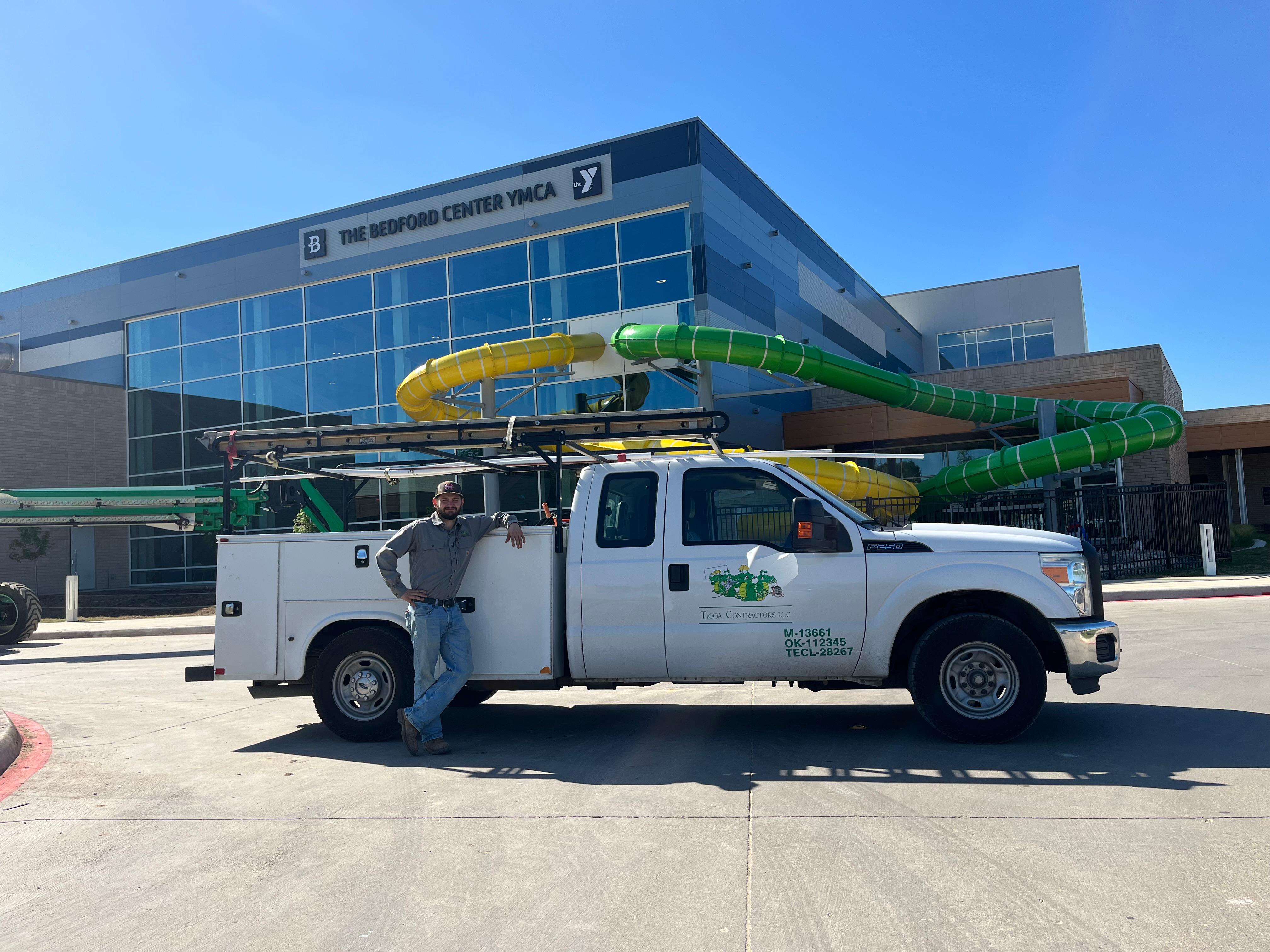 One of the Tioga Plumbing & Electric service techs with their truck in Bedford Texas at The Bedford Center YMCA.