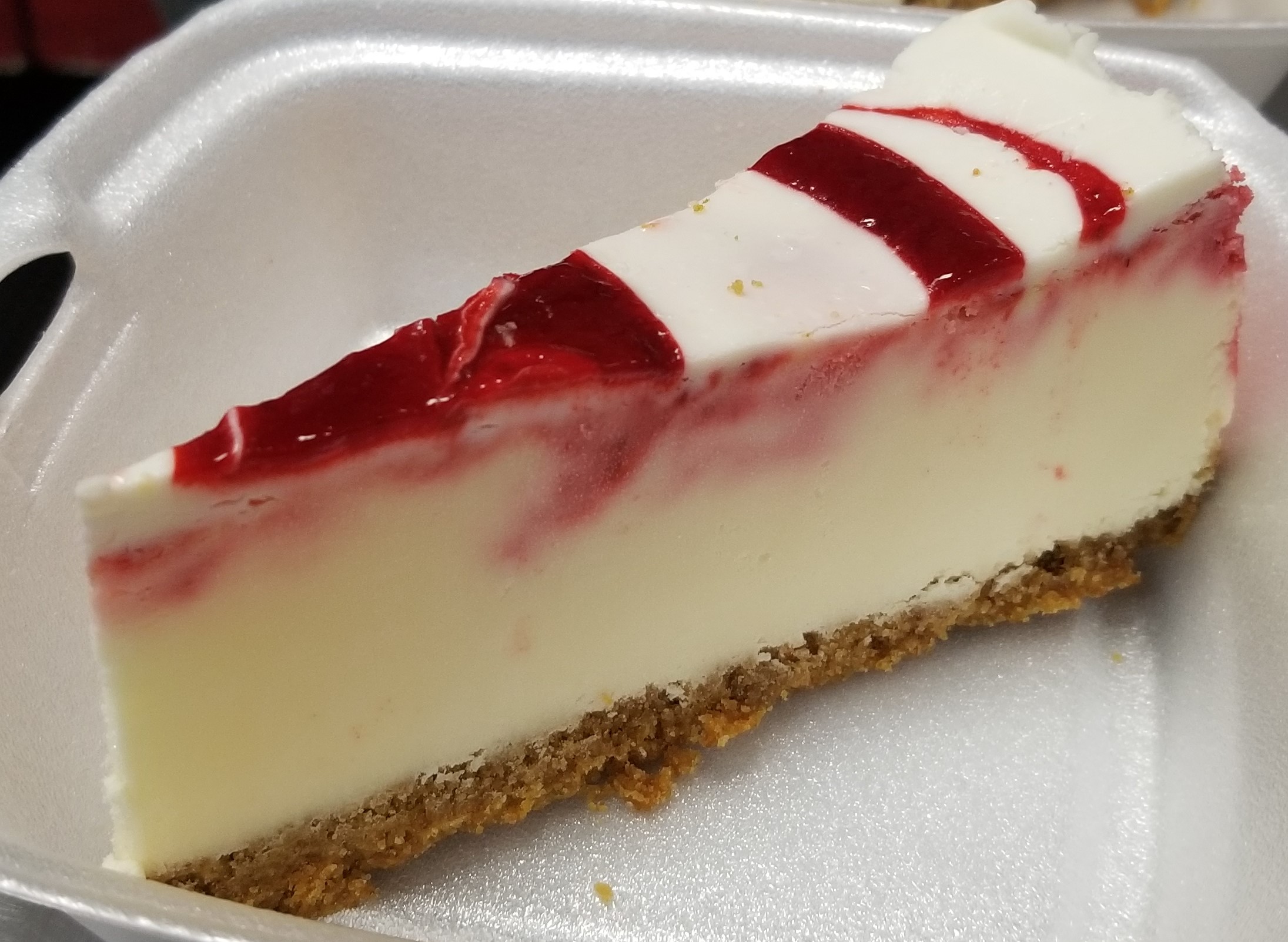 Classic New York Cheesecake with strawberry glaze drizzled on top!