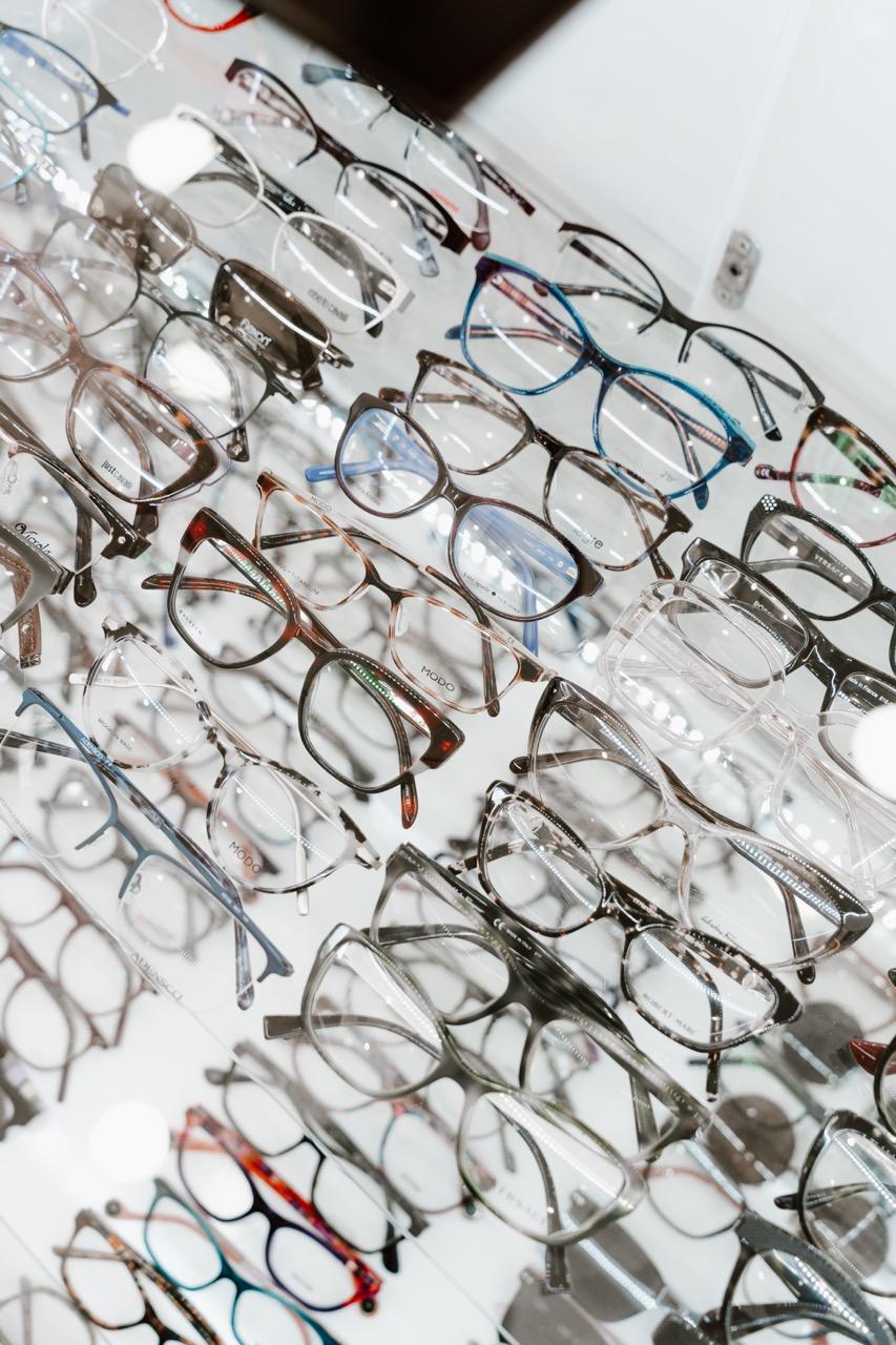 Close-up of designer eyeglass frames in different shapes and colors displayed at TK Optometry in Bro 