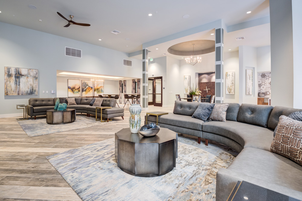 Resident clubhouse with huge wraparound couches and coffee tables.