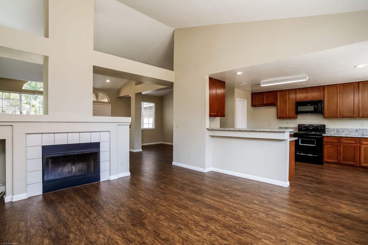 Kitchen and living room with fireplace and luxury-vinyl plank flooring at Invitation Homes Northern CA.