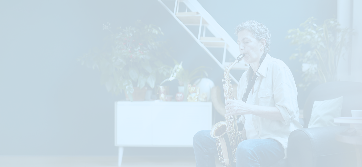 A woman practicing the saxophone in her nicely decorated living room.