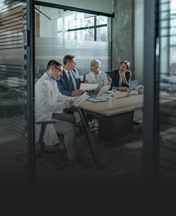A group of medical professionals working together at a boardroom table.