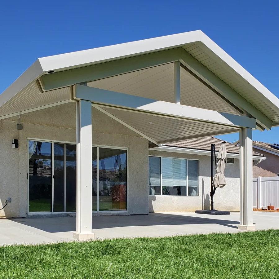 Solid Alumawood patio cover with peaked roofline, square columns, and recessed lighting.