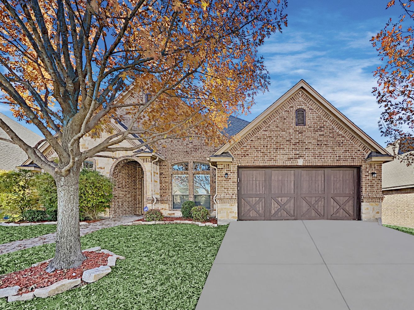 Front of home of a brick house and unique barn-style garage door at Invitation Homes Dallas.