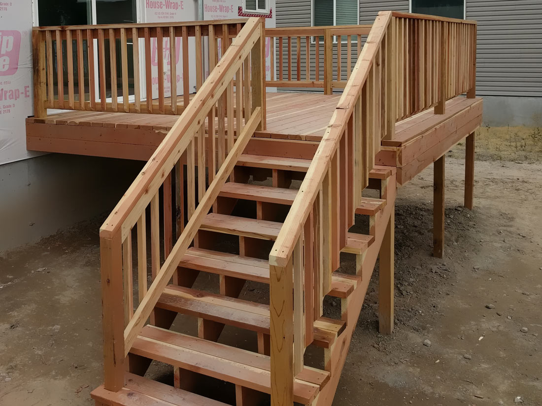Enhance your home's exterior with the timeless appeal of a custom natural wood deck by DeckPro LLC. This recently completed raised deck project features sturdy construction, classic wood railings, and convenient stairs connecting the living space to the backyard, perfect for enjoying the outdoors.