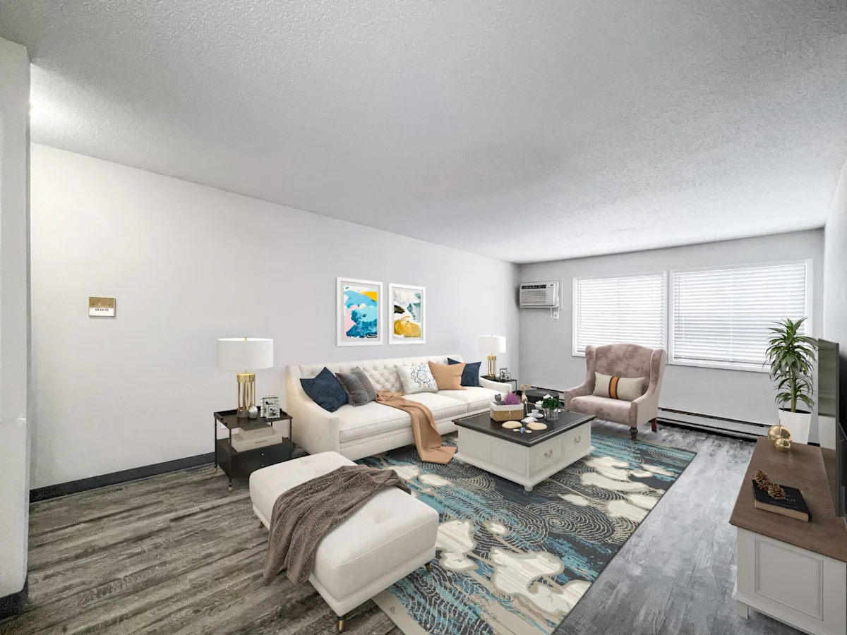 A living room with a white couch, a coffee table, and a television
