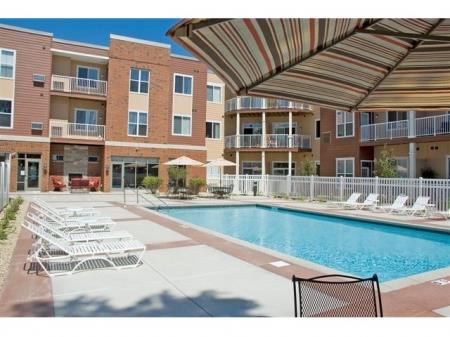 a swimming pool with chaise lounge chairs and umbrellas 