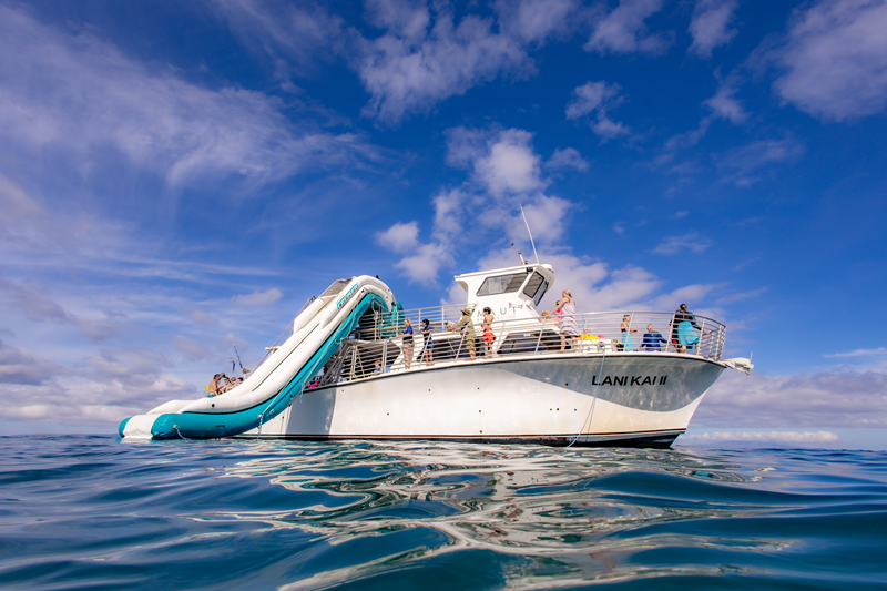 Guests aboard the Lani Kai II Maui Snorkeling Tours boat with ocean slide in clear Hawaiian waters