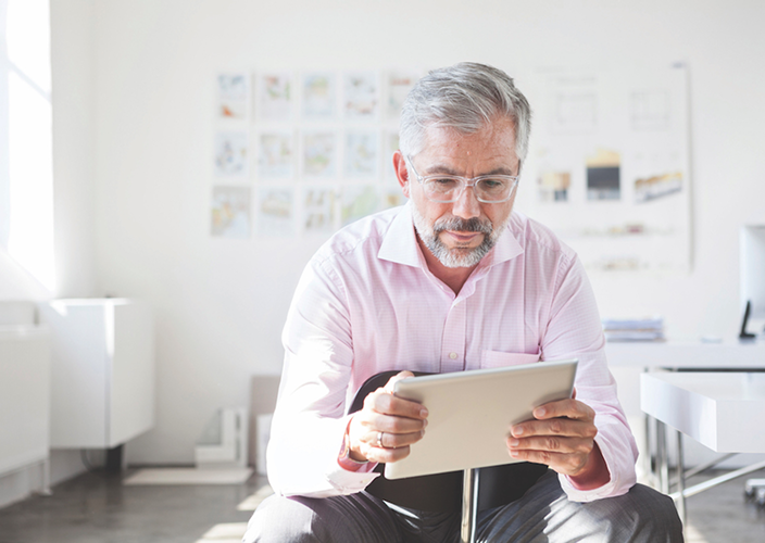 A professional reviewing documents on his iPad.