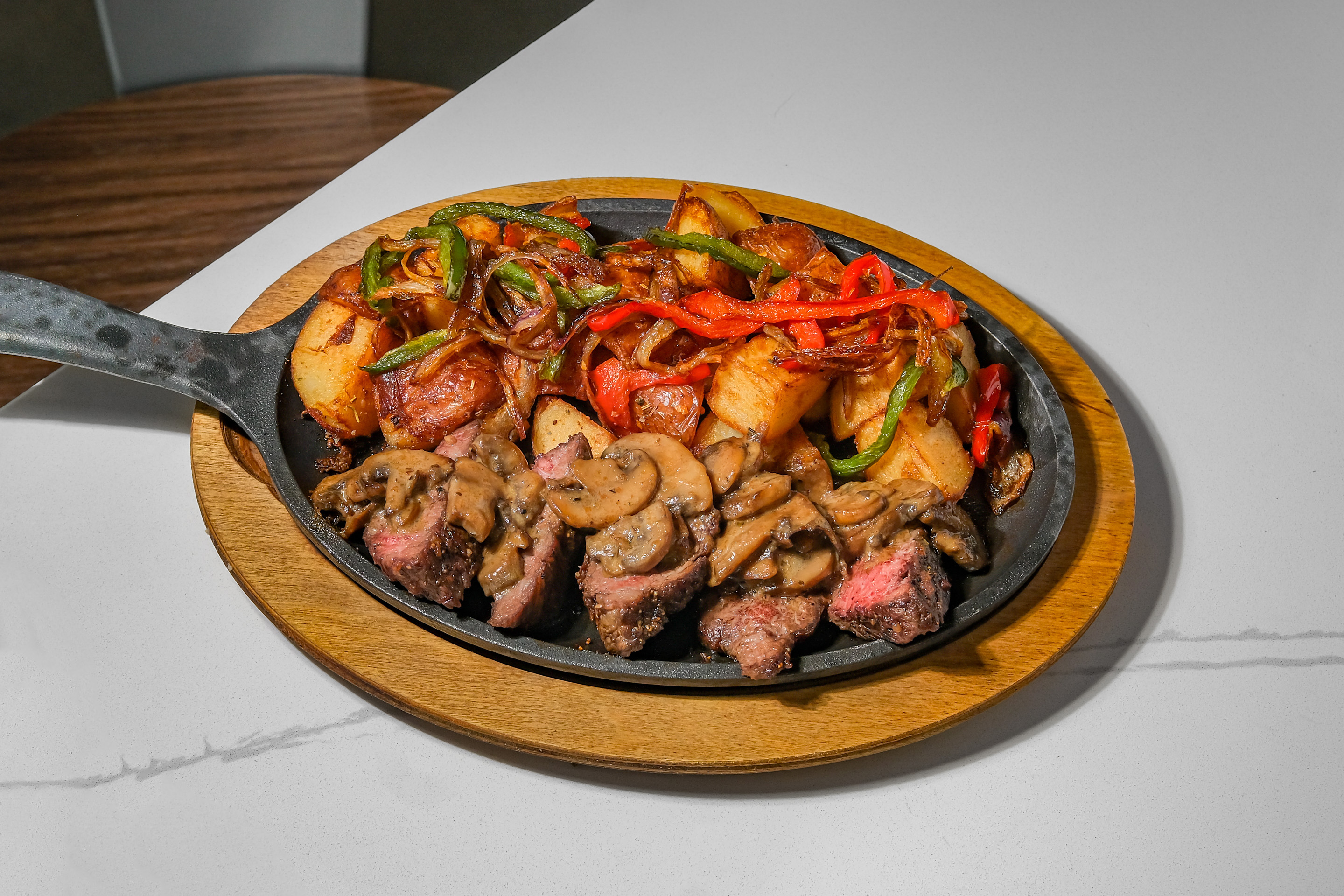 Sizzling skillet with juicy steak, eggs, and seasoned potatoes, packed with bold flavor.