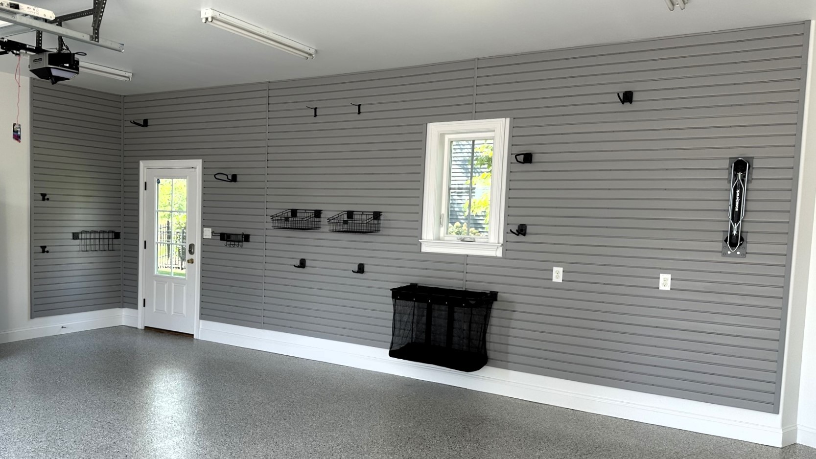 Floor-to-ceiling slatwall is a great way to get bikes and toys off the floor while protecting your drywall from nicks and scratches! Add an epoxy floor, and your garage is transformed!