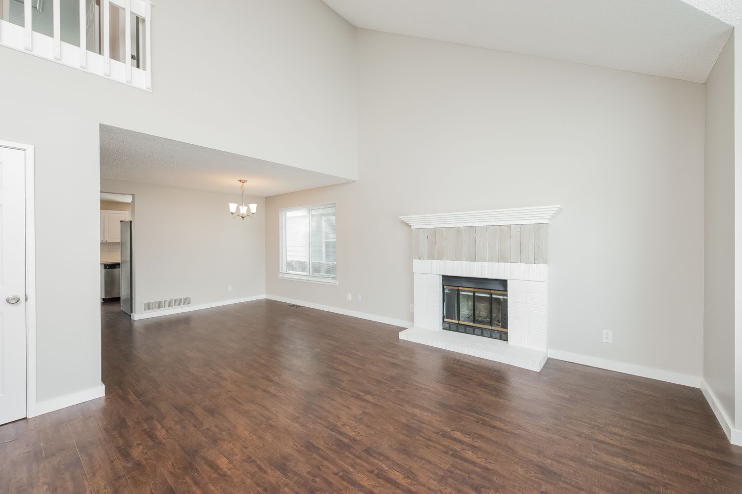 Living room with luxury vinyl plank flooring and a cozy fireplace at Invitation Homes Denver.