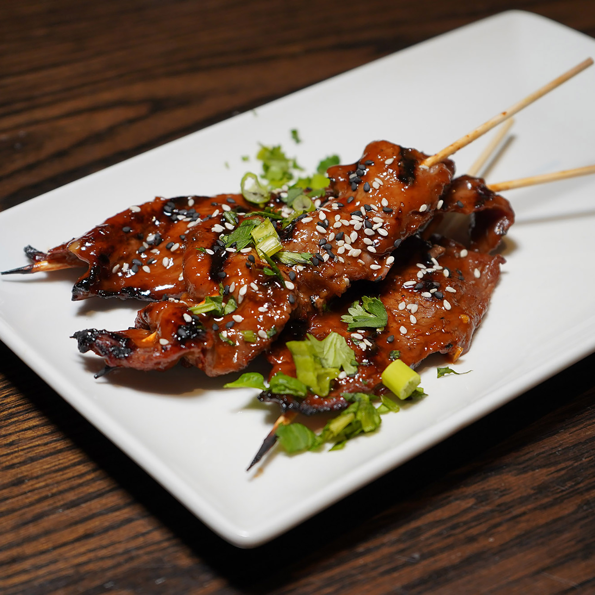 Steak Skewers from Burtons Happy Hour Menu. Asian bbq marinade, scallions, cilantro, sesame seeds.