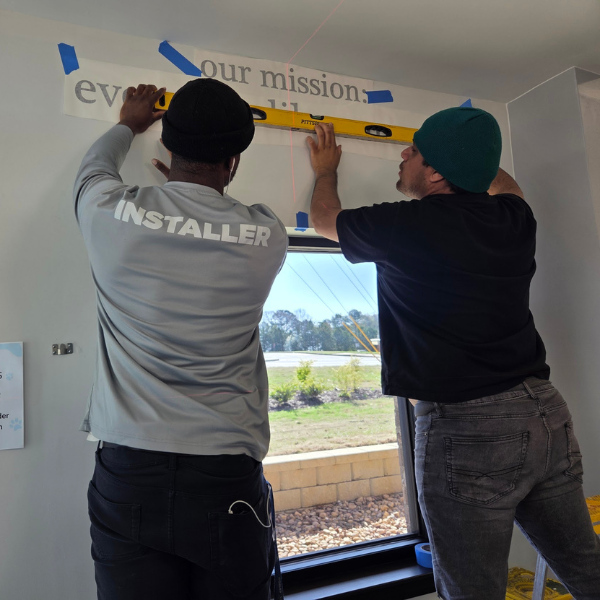 Professional sign installation team at Signary Custom Signs and Graphics installing a large exterior building sign for a commercial client. Our experts ensure precise placement and secure mounting for maximum visibility in Cumming, GA.