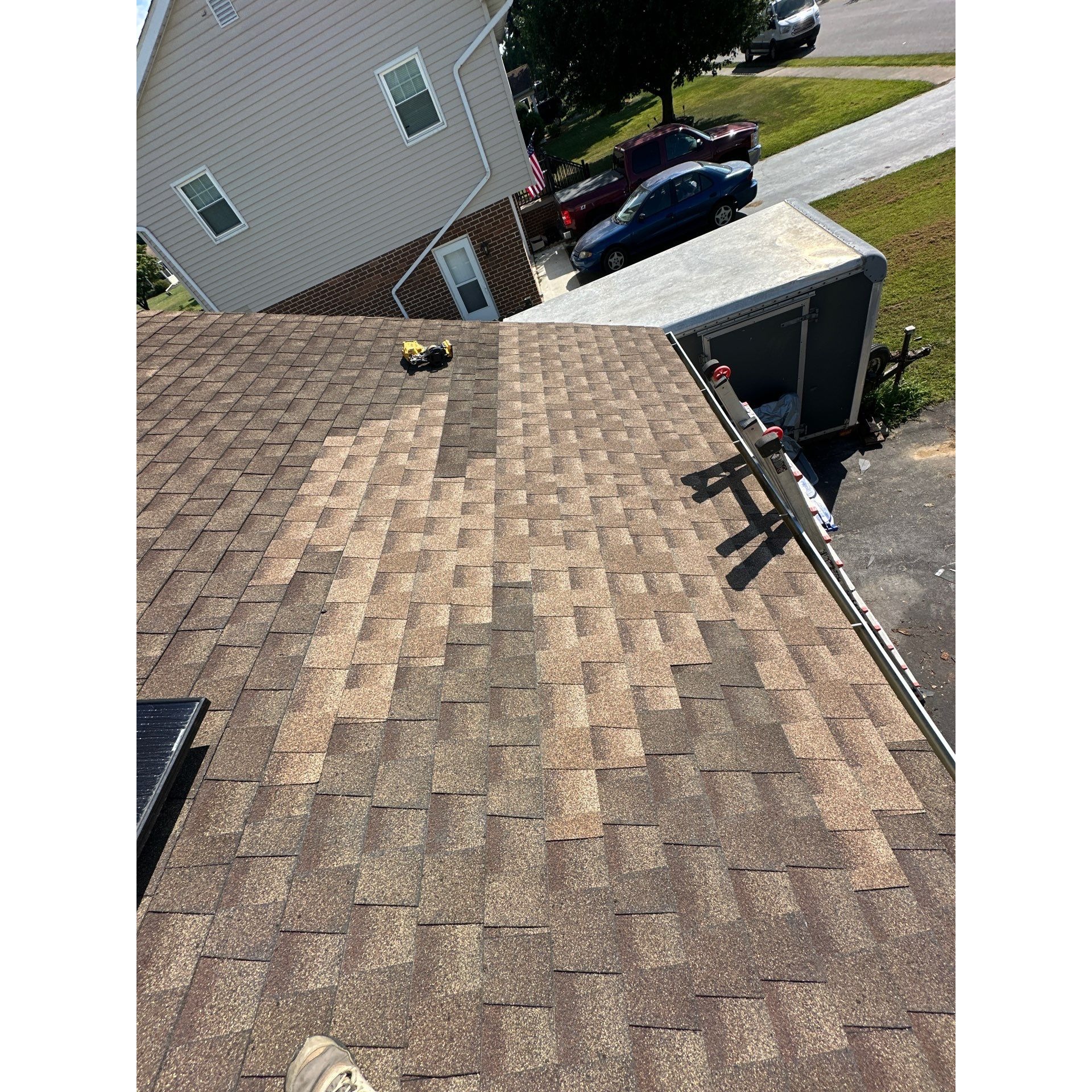 Completed architectural shingle roof repair in Central Maryland, showing the repaired section blende 