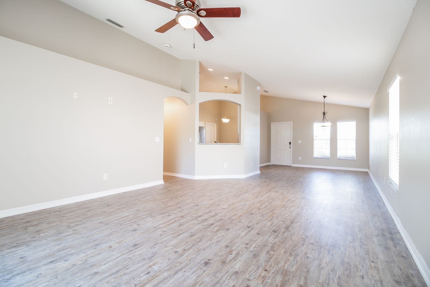 Spacious living room and dining area with vinyl plank flooring at Invitation Homes Orlando.