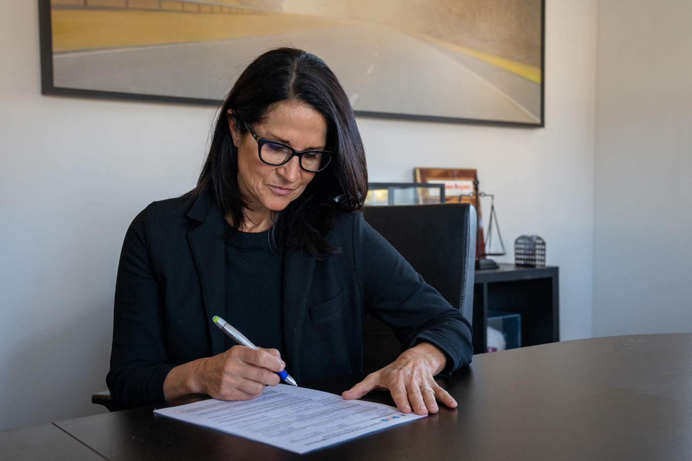 Attorney Kirsten Mendillo signing documents