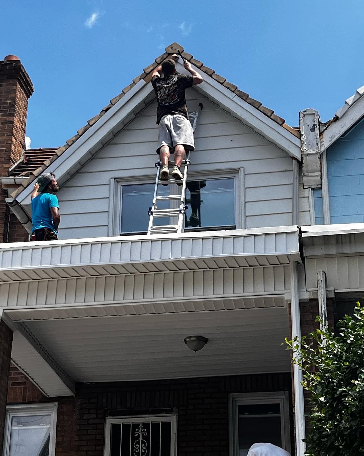 Contractors perform repairs and finishing work on a residential gable roof. Professional attention t 