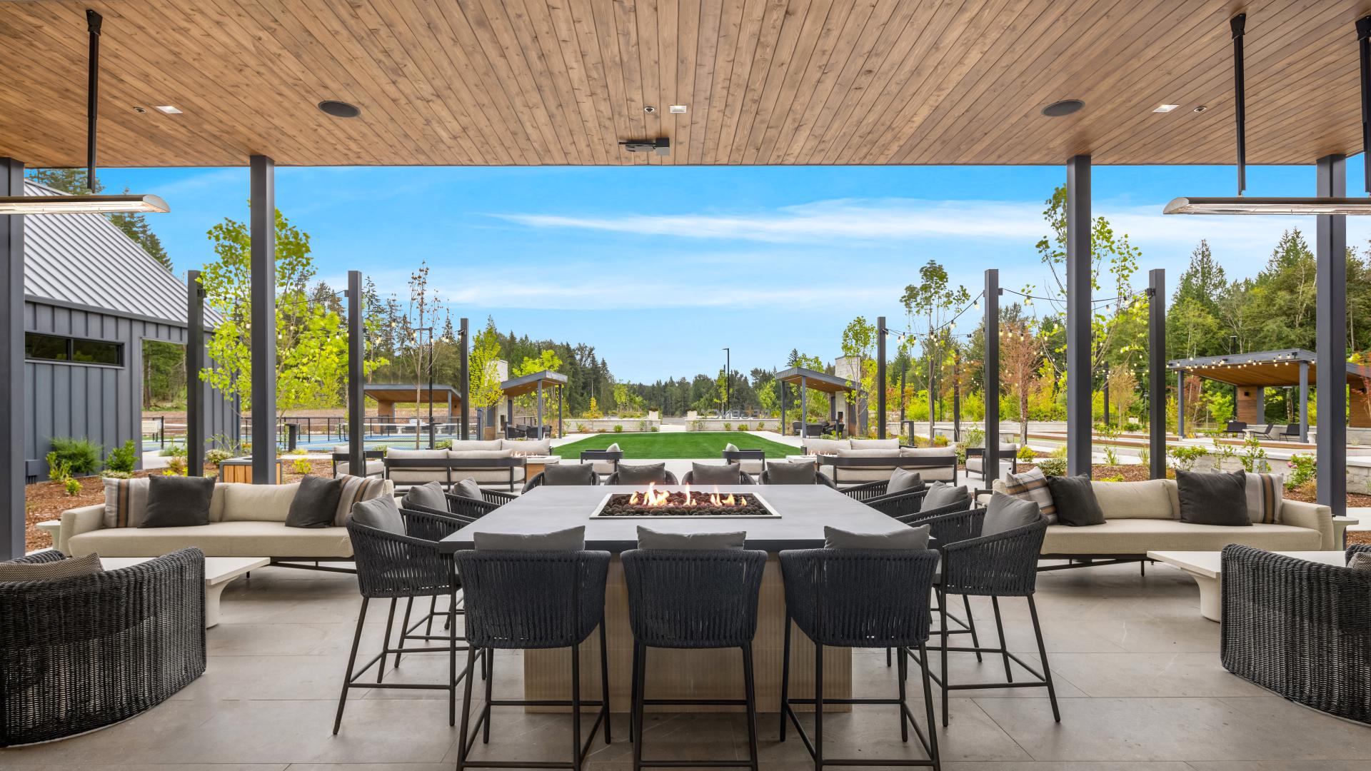 The covered patio features a fire table and couches for neighbors to meet