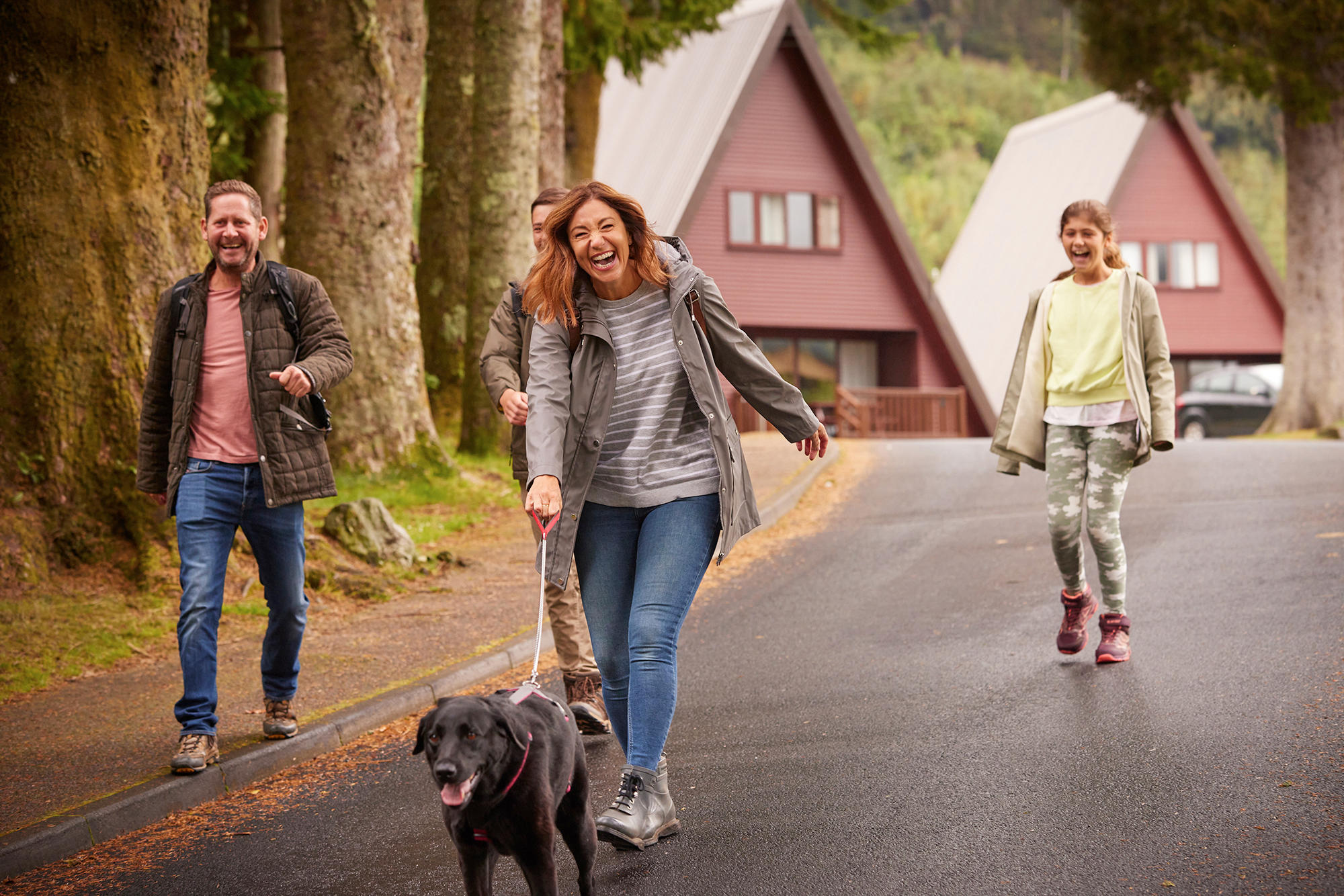 Family take a stroll with their dog through the grounds of Drimsynie Estate Holiday Village