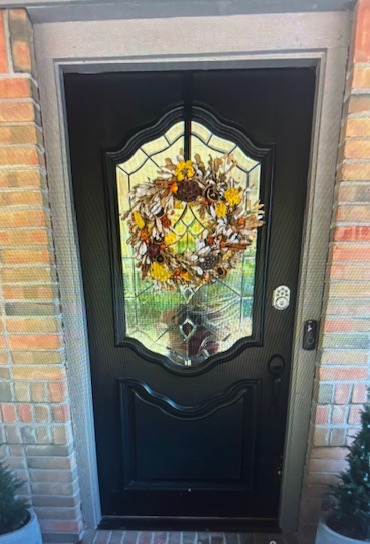 Black residential front entry door featuring an oval decorative leaded glass insert with beveled detailing, designed to enhance curb appeal and natural light while maintaining security.