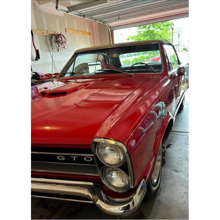 Detailed classic Pontiac GTO featuring polished red paint, clean chrome, and a well-maintained exter 