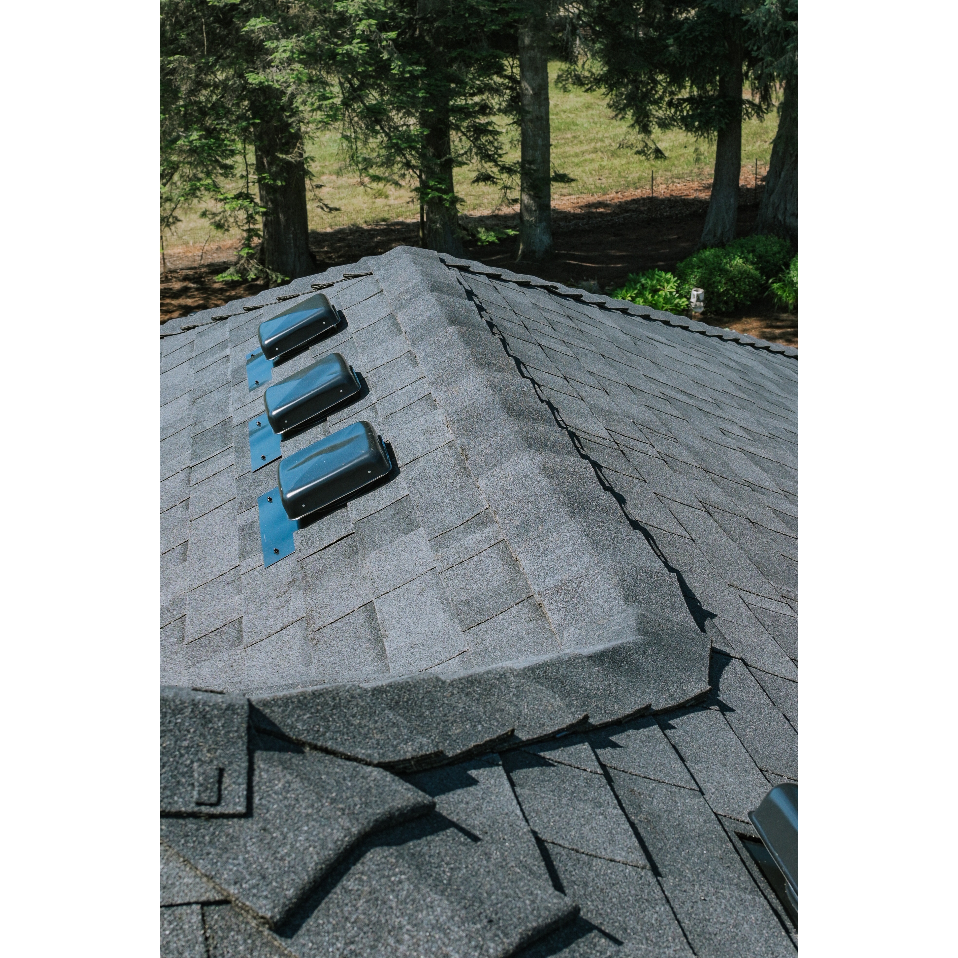 Finished roof ridge showing clean shingle transition and water-shedding details. 