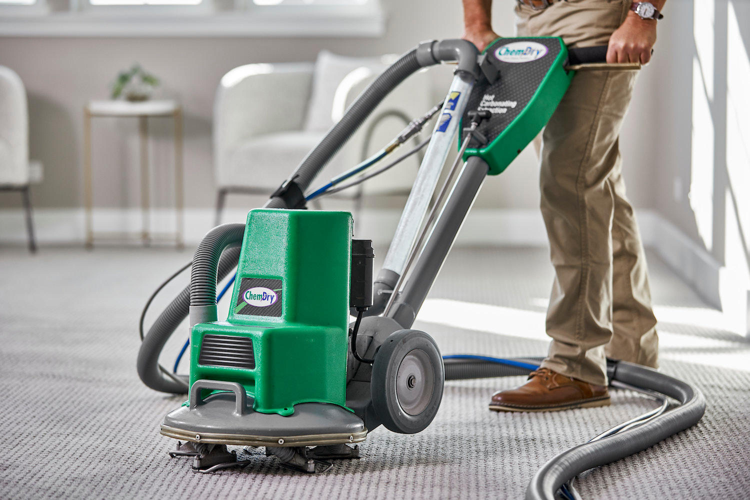 Chem-Dry tech using a carpet cleaning powerhead in a living room