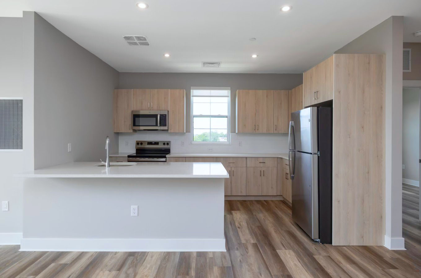 A modern, chef-inspired kitchen at Creekline at Fairfield features a sleek breakfast bar and premium stainless steel appliances.