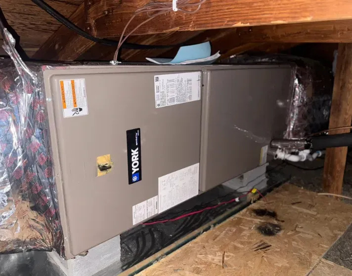 York HVAC air handler installed horizontally in an attic, connected to insulated ductwork, refrigera 