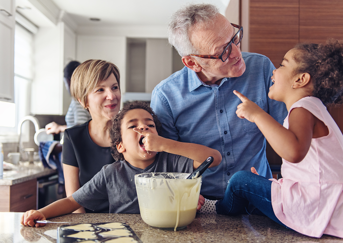 A multigenerational family baking cookies together.