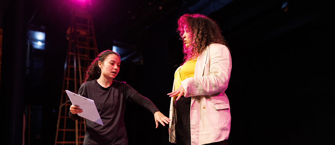 Young woman giving stage directions to a performer.