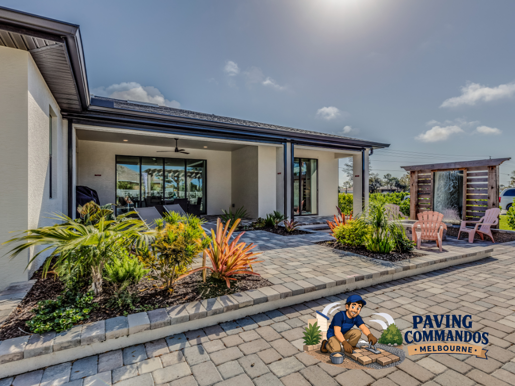 Residential patio and walkway featuring interlocking pavers, landscaped planting beds, and an inviting outdoor living area.