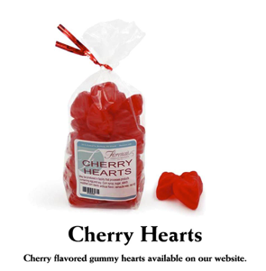 This photograph features a bag of Florence's Exquisite Chocolates' "Cherry Hearts," presumably from their Rexburg, Idaho location. The clear bag showcases the bright red, heart-shaped candies, tied with a festive red ribbon. The product label clearly states "Cherry Hearts" and includes a barcode. Several loose cherry hearts are scattered beside the bag, one distinctively shaped like a pair of lips, revealing their gummy or jelly texture.